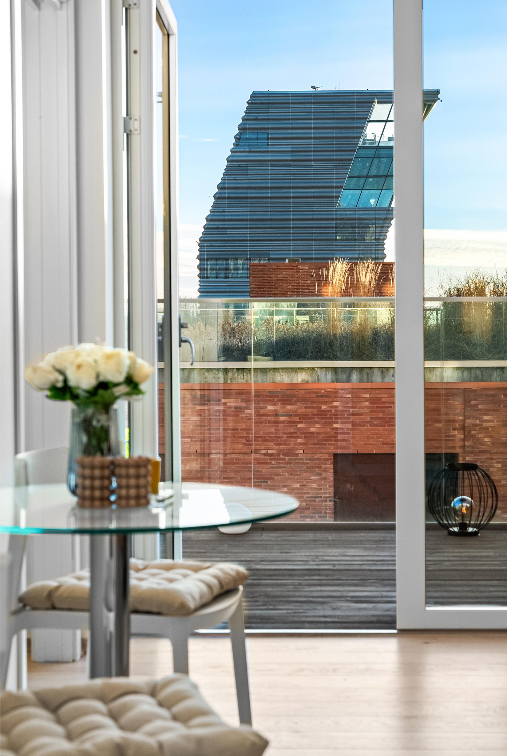 Fantastisk utsikt mot Munchmuseet fra leiligheten. Store doble glassdører fører ut til en romslig balkong med flott utsyn